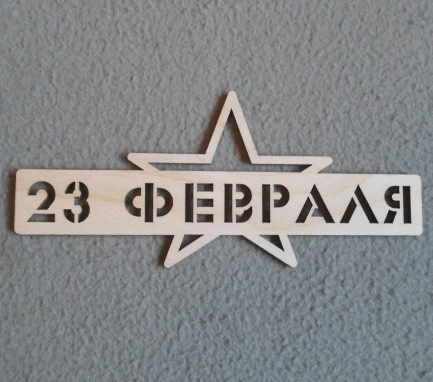 Надпись «23 февраля», прорезанная трафаретным шрифтом в полосе фанеры